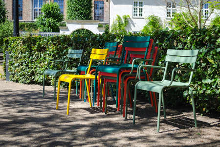 Multi-colored garden chairs against the background of a green park. Summer sunny day.の写真素材