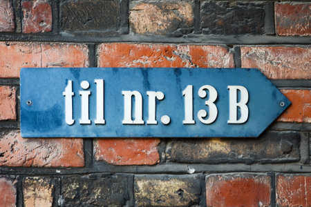 A sign on a brick wall, with the inscription of the Till Nr. 13B. Pointers. Signs.の写真素材