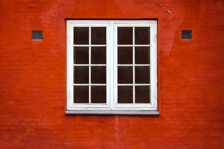 Beautiful old window on a background of the red brick wall. Architecture. Details.の写真素材