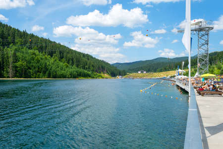 Bukovel. Ukraine. 17. July. 2021. Lake of Youth. Nice view of the mountain lake, with the beach. Carpathians. Summer Vacation Travelのeditorial素材