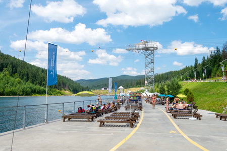 Bukovel. Ukraine. 17. July. 2021. Lake of Youth. People are relaxing on the beach, a beautiful mountain lake .. Carpathians Summer Vacation Travelのeditorial素材