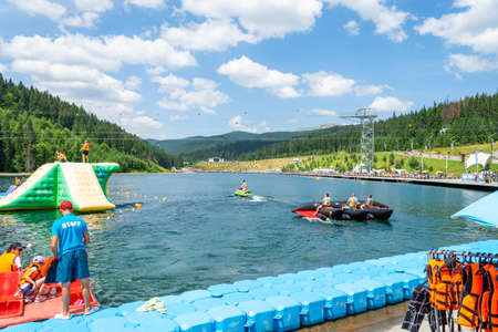Bukovel. Ukraine. 17. July. 2021. Lake of Youth. People are resting and having fun at water attractions. Carpathians. Summer Vacation. Travelのeditorial素材