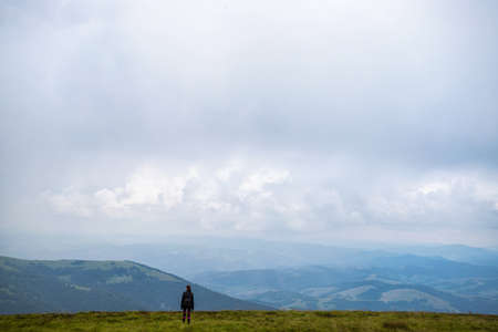 Girl with a backpack in the mountains. Low clouds. Fog. Solitude with nature. Loneliness. Freedom....