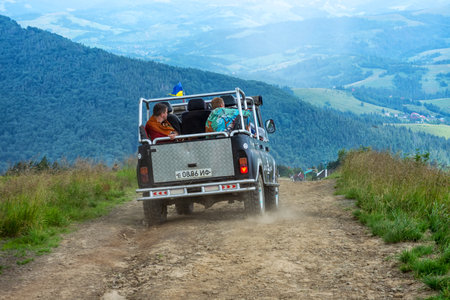 Mount Gymba. Carpathians. Ukraine. July 25, 2020. An off-road vehicle descends from the mountain with tourists. Extreme vacation. Carpathians. Transport. Vacation. Travelのeditorial素材