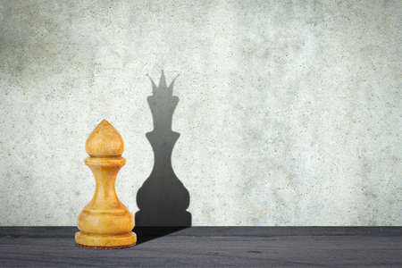 White pawn with the shadow of the queen. Motivation concept. Strength and aspirations. Confidence in your strength. Business. Lifestyle. Abstract background. Background.の写真素材