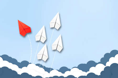 Red paper plane flying in a different direction than the white ones. Cloudy sky. Copy space. The concept of innovative solutions, creativity. Business. Lifestyle. Background.の写真素材