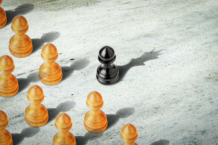 Black pawn with the shadow of the queen, in front of the white pawns. Leadership concept. Strength and aspirations. Confidence in your strength. Business. Lifestyle. Abstract background. Background.の写真素材