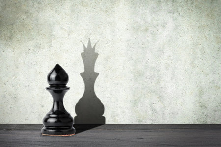 Pawn with the shadow of the queen. Motivation concept. Strength and aspirations. Confidence in your strength. Business. Lifestyle. Abstract background. Background.の写真素材