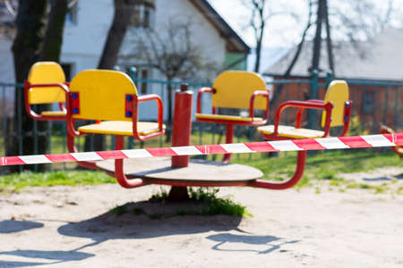 Barrier tape on a children's swing. Indoor playground for quarantine. KOVID 19. Quarantine.の写真素材
