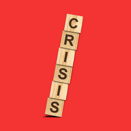 Crisis. Falling pyramid of wooden blocks on a red background. Crisis. Business. Finance. The collapse of the economy.の写真素材