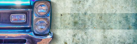 Headlight of an old beautiful dark blue car on a concrete wall background. Copy space concept for repair banners, car sale. Close-up.の写真素材