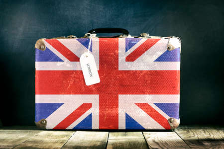 Old suitcase with English flag on wooden background. Travels.の写真素材