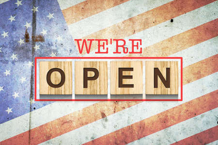 We are open. The inscription on wooden blocks on the background of the flag of America. Business.Travel.の写真素材
