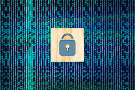 Information or network protection. Lock icon on a wooden block on a binary code background on a dark background. Cybernetic web services for business and online projects. Data protection.の写真素材