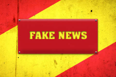 Fake news. The inscription on a red plate on the background of the flag of Spain. Information Technology.の写真素材
