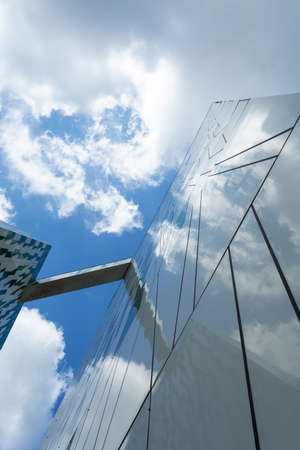 Copenhagen. Denmark. July 24th. 2019: Facade of a glass building. Cloudy sky Bottom view. Close-up....