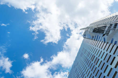 2019: Beautiful modern building made of metal on a background of cloudy sky. View from below. Power...