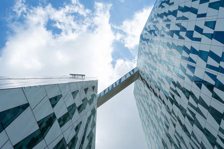 Copenhagen. Denmark. July 24th. 2019: Facade of a glass building. Cloudy sky Bottom view. Close-up....
