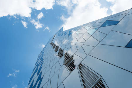 Facade of a glass building. Cloudy sky Bottom view. Close-up. Architecture Backgroundsのeditorial素材