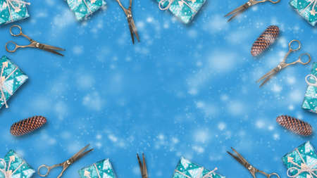 New Year's gifts, cones and hairdressing scissors on a blue background. Copy space. Place for text. Congratulations to the hairdresser. New Year. Christmas background. Festive background.の写真素材