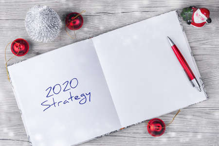 2020. Srategy. Concept of ideas and goals for the new year. Notepad with festive decor on a wooden...