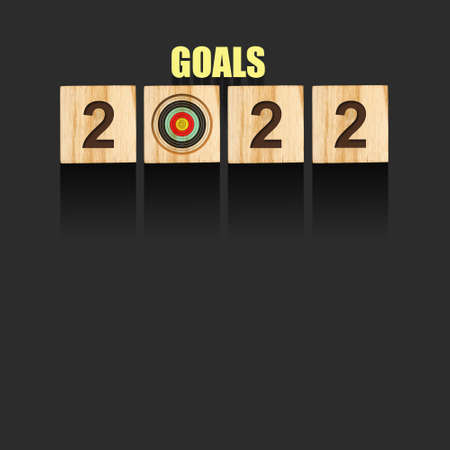Concept. Goals for 2022. Target and numbers on wooden blocks on a gray background. Copy space....