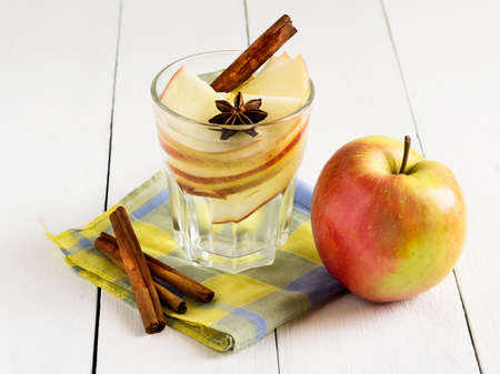 Detox water with apple, cinnamon and anise on a white wooden backgroundの写真素材