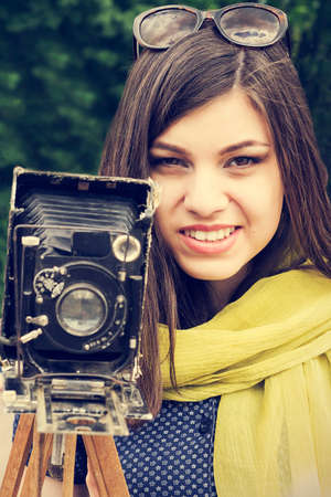 Portrait of a beautiful young girl with a retro camera. Retro style.