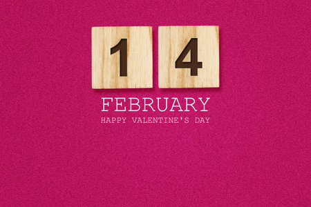 February 14 on a wooden block. Pink background. Happy Valentine's day greeting card. Holiday background.の写真素材