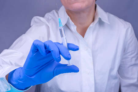Doctor in a medical glove with a syringe. Close-up. Vaccinations. Medicine. Treatment. Prevention