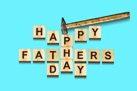 Happy Father's Day inscription on wooden cubes with working tools on blue background, isolated. Happy Father's Day Concept. Greetings and gifts.Holidays.の写真素材