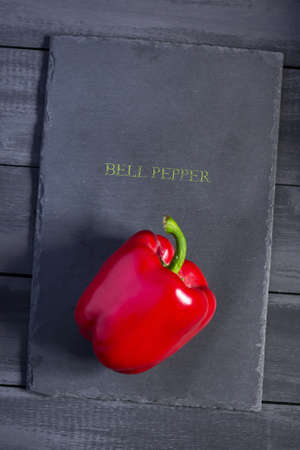 Sweet bell peppers on stone cutting board. Copy space. Natural, organic products. Dark wooden background.の写真素材