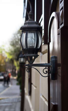 The old street lamp on the stone wall background