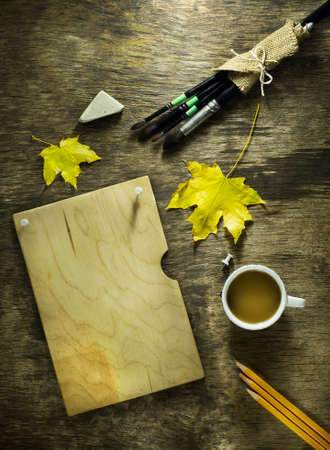Art brush with sketches and autumn leaves on a wooden backgroundの写真素材