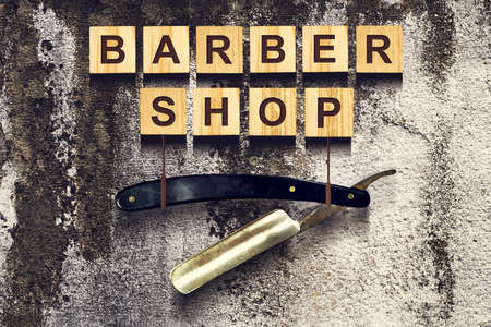 Concept Barber Shop. An inscription on wooden cubes against the background of an old vintage wall. Beauty. Fashionの写真素材