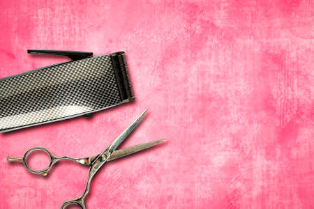 Hair clipper, and hairdresser scissors, on a pink background. Copy space. Hairdressing tools. Beauty and fashion.の写真素材