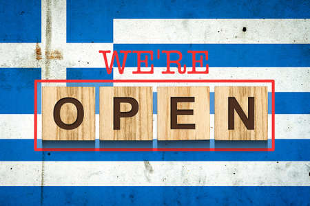 We are open. The inscription on wooden blocks against the background of the flag of Greece. Business. Travel.の写真素材