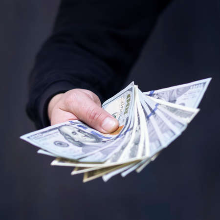 Hand on cash. Finance. Corruption. Illegal transactions Dark backgroundの写真素材