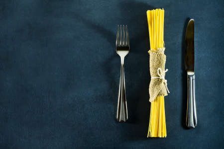Different types of dry Italian pasta on a dark blue background. Top view with copy spaceの写真素材