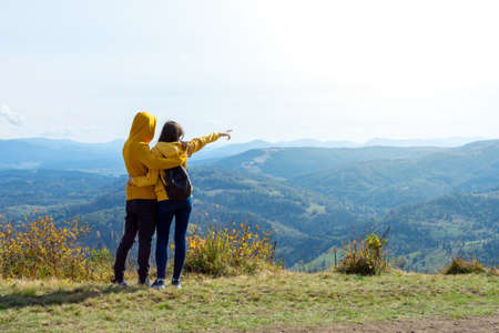 A young couple admiring the beautiful mountain views. Travels.の写真素材