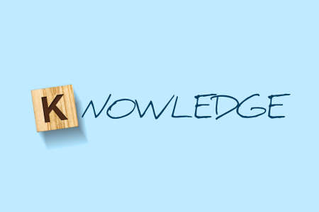 Knowledge. Words written on a wooden block. Blue Background Isolated. Business education concept.の写真素材