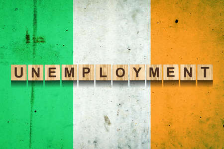 Unemployment. The inscription on wooden blocks on the background of the Ireland flag. Unemployment growth. Business. Job.の写真素材