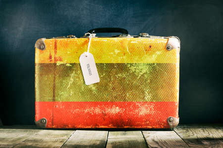 Old suitcase with the Lithuania flag on wooden background. Travelsの写真素材