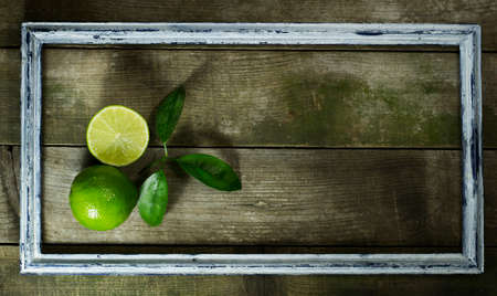 Lime in the old frame on a wooden backgroundの写真素材