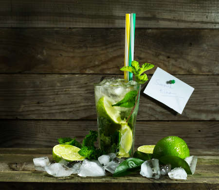 Glass with Mojito and crushed ice on wooden backgroundの写真素材