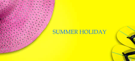Concept of a summer holiday. Pink beach hat and beach slippers on a bright yellow background. Copy space. Top View. Place for text. Easy to clean text. Summer holiday banner. Summer background.の写真素材