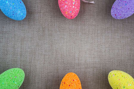 Multicolored easter eggs on a background of gray fabric. Copy space. Easter background.