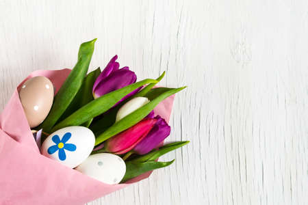 Tulips and Easter eggs on a white wooden background. Easter background.Greeting cardの写真素材