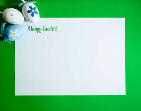Easter composition with colorful eggs on a green background with copy space