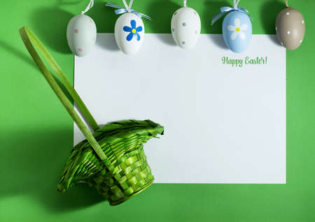 Easter composition with colorful eggs on a green background with copy space